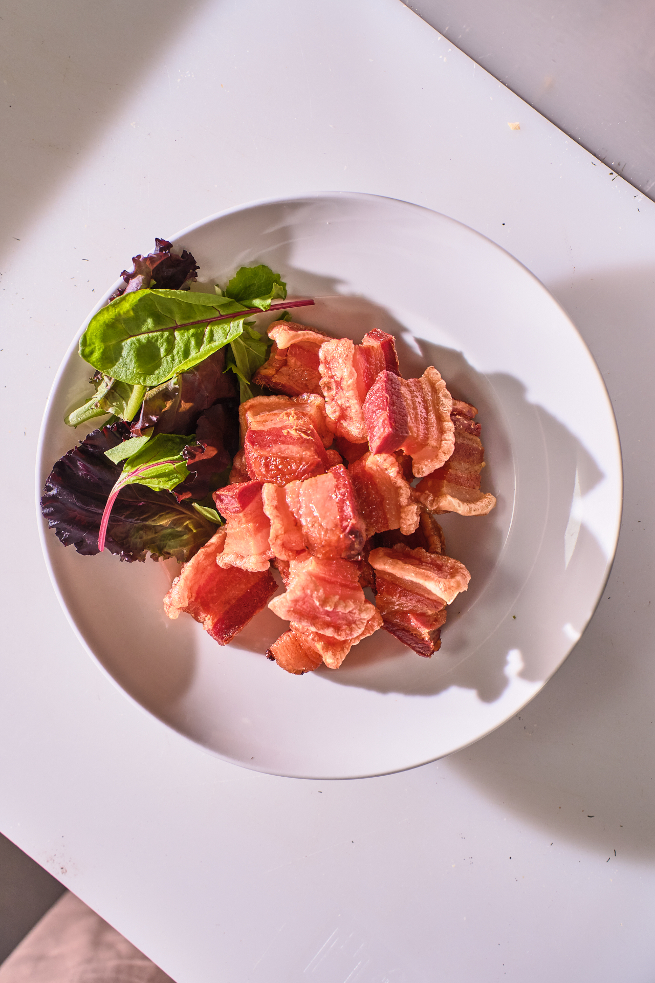 Plato de torreznos crujientes con hojas verdes